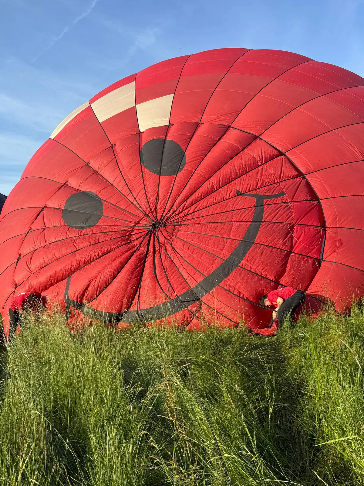 vue sur le haut du ballon d'Art Montgolfières avec un smiley au moment du gonflage